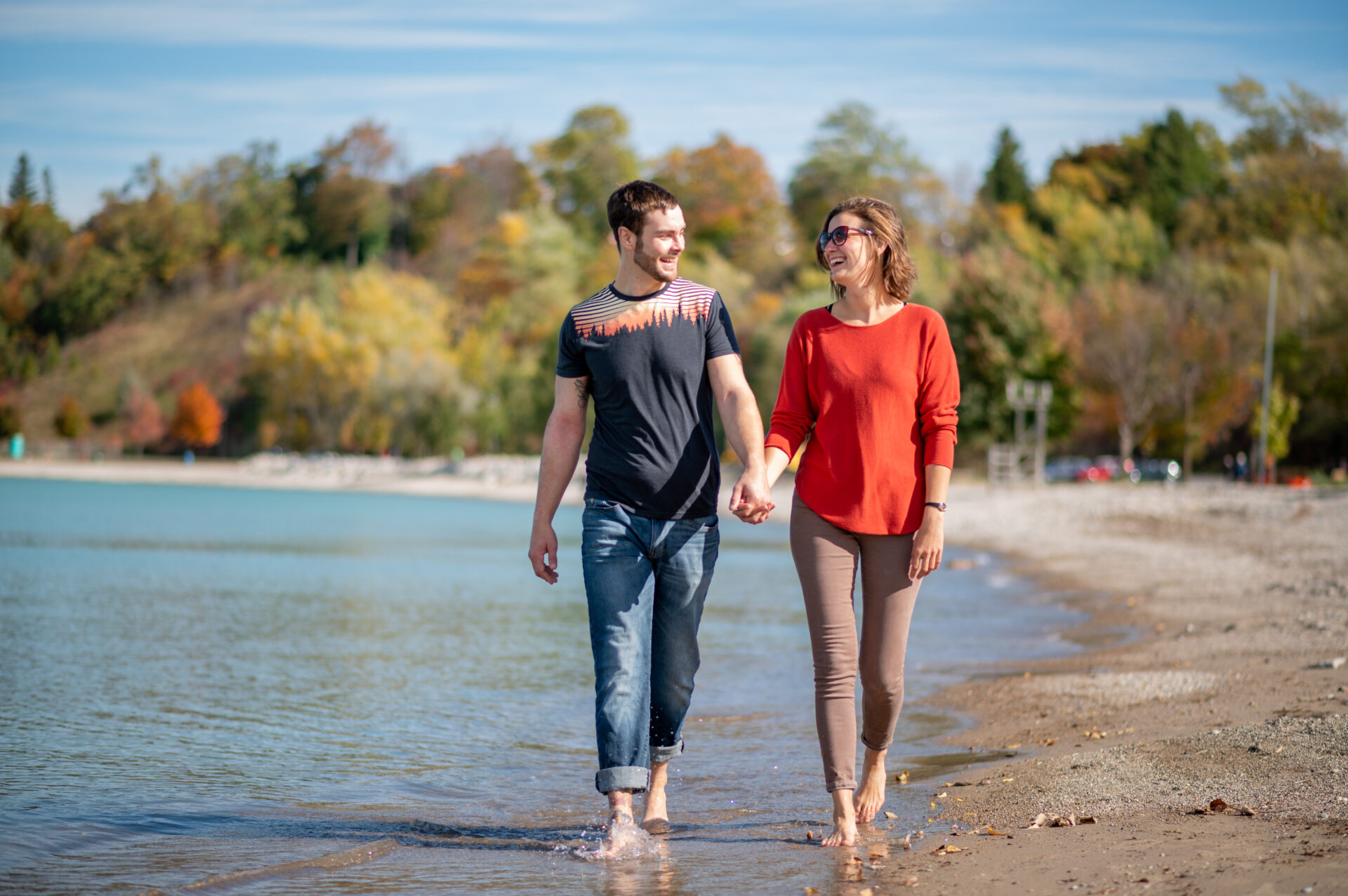Man and woman walking along the beach holding hands